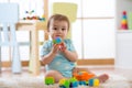 Baby boy playing with colorful plastic bricks on the floor. Toddler having fun and building out of constructor bricks Royalty Free Stock Photo