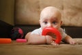 Baby boy playing with developing toy lying on sofa. Early baby development concept. Royalty Free Stock Photo