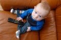 Baby boy playing with TV remote