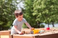 A baby boy plays with toys, cars in the sand on the playground. Kindergarten Royalty Free Stock Photo