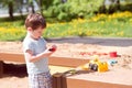 A baby boy plays with toys, cars in the sand on the playground. Kindergarten Royalty Free Stock Photo