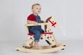 Baby boy riding a wooden rocking horse Royalty Free Stock Photo