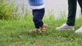 Baby boy's first steps, mother follows, close-up, slow motion