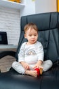 Baby boy sitting on a boss chair. Small child on a leather office chair.