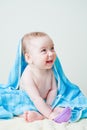 Baby Boy Sitting Covered by Blue Towel Holding Toy