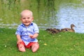 Baby boy sitting on the grass in the park Royalty Free Stock Photo