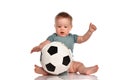 Baby boy sitting and playing a classic soccer ball on a white background. Royalty Free Stock Photo