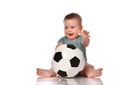Baby boy sitting and playing a classic soccer ball on a white background Royalty Free Stock Photo