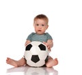 Baby boy sitting and playing a classic soccer ball on a white background. Royalty Free Stock Photo