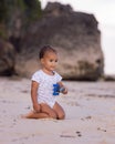 Baby boy sitting on sandy beach, holding toy car. Warm sunny day. Happy childhood. Summer vacation at the sea. Spending time near Royalty Free Stock Photo