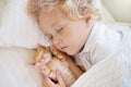 Baby boy sleeping with kitten. Child and cat Royalty Free Stock Photo