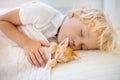 Baby boy sleeping with kitten. Child and cat Royalty Free Stock Photo