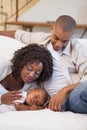 Baby boy sleeping peacefully on couch with happy parents Royalty Free Stock Photo