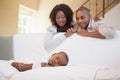 Baby boy sleeping peacefully on couch watched by parents Royalty Free Stock Photo