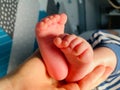 Baby boy small feet, no socks, little toes, playing in bed, blue stripes pijamas Royalty Free Stock Photo