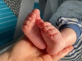 Baby boy small feet, no socks, little toes, playing in bed, blue stripes pijamas Royalty Free Stock Photo