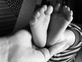 Baby boy small feet, no socks, little toes, playing in bed, blue stripes pijamas Royalty Free Stock Photo