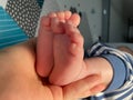 Baby boy small feet, no socks, little toes, playing in bed, blue stripes pijamas Royalty Free Stock Photo