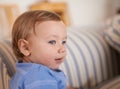 Baby boy, smile and face profile in sofa relaxing, resting and sitting in living room. Adorable child, growth and Royalty Free Stock Photo