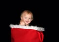 Baby boy smiling sitting in red basket with fur lining black background Royalty Free Stock Photo