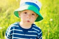 Baby boy standing in grass on the fieald with dandelions Royalty Free Stock Photo