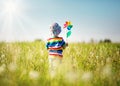 Baby boy standing in grass on the fieald with dandelions Royalty Free Stock Photo