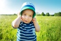 Baby boy standing in grass on the fieald with dandelions Royalty Free Stock Photo