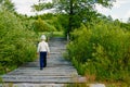 Baby boy stands on a wooden bridge over a river and blue sky Royalty Free Stock Photo