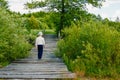 Baby boy stands on a wooden bridge over a river and blue sky Royalty Free Stock Photo