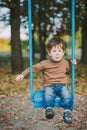 Baby boy swinging in autumn park Royalty Free Stock Photo