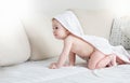 Cute baby boy with towel with hood on head crawling on bed Royalty Free Stock Photo