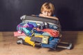Baby boy and Travel Suitcase. Kid and Luggage Packed for Vacation Full of Clothes, Child and Family Trip Royalty Free Stock Photo