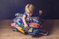 Baby boy and Travel Suitcase. Kid and Luggage Packed for Vacation Full of Clothes, Child and Family Trip Royalty Free Stock Photo