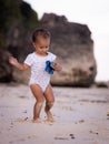 Baby boy walking on sandy beach, holding toy car. Warm sunny day. Happy childhood. Summer vacation at the sea. Spending time near Royalty Free Stock Photo