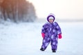 Baby boy walking at snowfield. Child in winter clothes standing on snowy sea shore Royalty Free Stock Photo