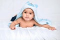 Baby boy wearing diaper with towel on white bed Royalty Free Stock Photo