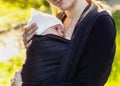 Baby on the breast of the mother. Newborn woven wrap babywearing
