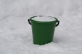 Baby bucket with snow inside and standing in the snow. Royalty Free Stock Photo