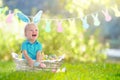 Baby with bunny ears on garden Easter egg hunt Royalty Free Stock Photo