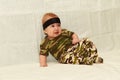 The baby in camouflage clothes on a white background