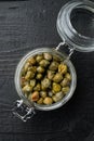 Baby capers in marinate glass jar, flat lay