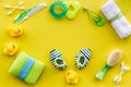 Baby care accessories, toys and clothing on yellow background top view mock up Royalty Free Stock Photo