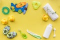 Baby care accessories, toys and clothing on yellow background top view mock up Royalty Free Stock Photo