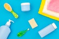 Baby care. Bath cosmetics and accessories for child. Shampoo, gel, cream, towel, brush on blue background top view Royalty Free Stock Photo