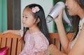 Baby care after bathing, mother is combing daughter`s hair Royalty Free Stock Photo