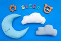 Baby care concept with moon pillow, clouds, sleep copy and toy for sleep of newborn on blue background top view