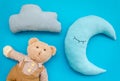 Baby care concept with moon pillow, clouds, teddy bear and toy for sleep of newborn on blue background top view Royalty Free Stock Photo