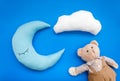 Baby care concept with moon pillow, clouds, teddy bear and toy for sleep of newborn on blue background top view Royalty Free Stock Photo