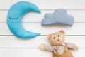 Baby care concept with moon pillow, clouds, teddy bear and toy for sleep of newborn on white wooden background top view Royalty Free Stock Photo