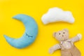 Baby care concept with moon pillow, clouds, teddy bear and toy for sleep of newborn on yellow background top view Royalty Free Stock Photo